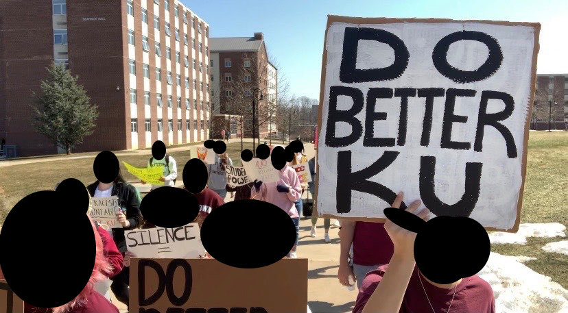 Protesters marching on Kutztown campus. Sign reads "Do Better KU