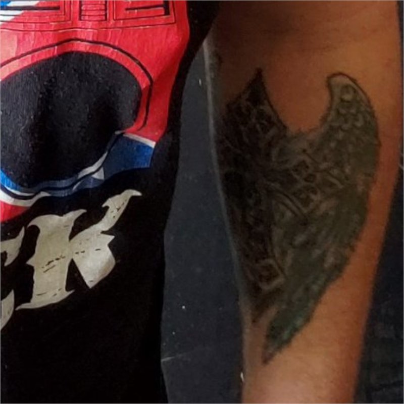 Cross tattoo on left forearm